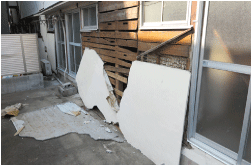 地震被害により民家の壁が剥がれ落ちた状態